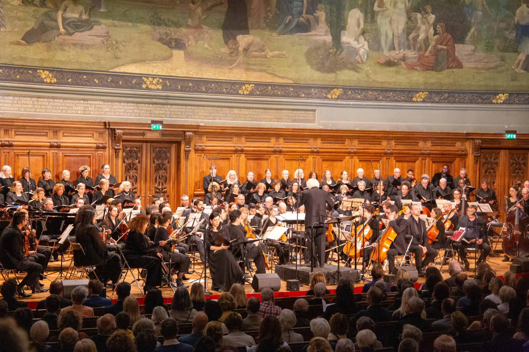 Le chœur et l'orchestre en pleine interprétation sous la direction de Murry Sidlin, Grand Amphithéâtre de la Sorbonne, 19 mai 2026
