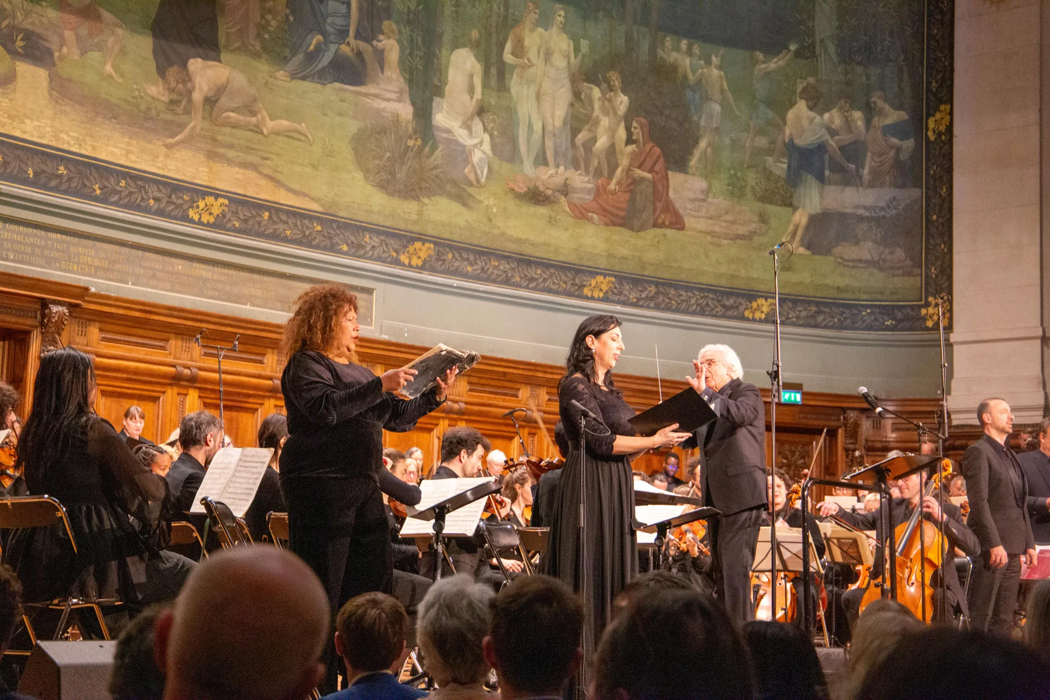 Deux solistes en performance sur scène avec le chef au Grand Amphithéâtre de la Sorbonne lors du concert Defiant Requiem : Verdi à Terezín, 19 mai 2026