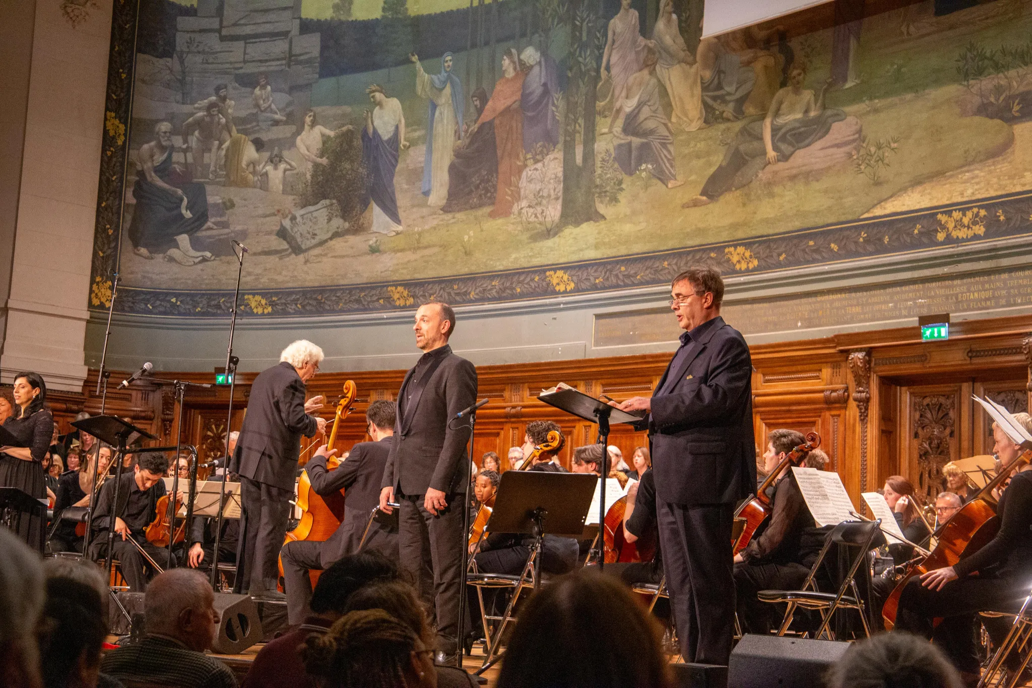 Solistes masculins et chef d'orchestre sur scène au Grand Amphithéâtre de la Sorbonne lors du concert Defiant Requiem : Verdi à Terezín, 19 mai 2026