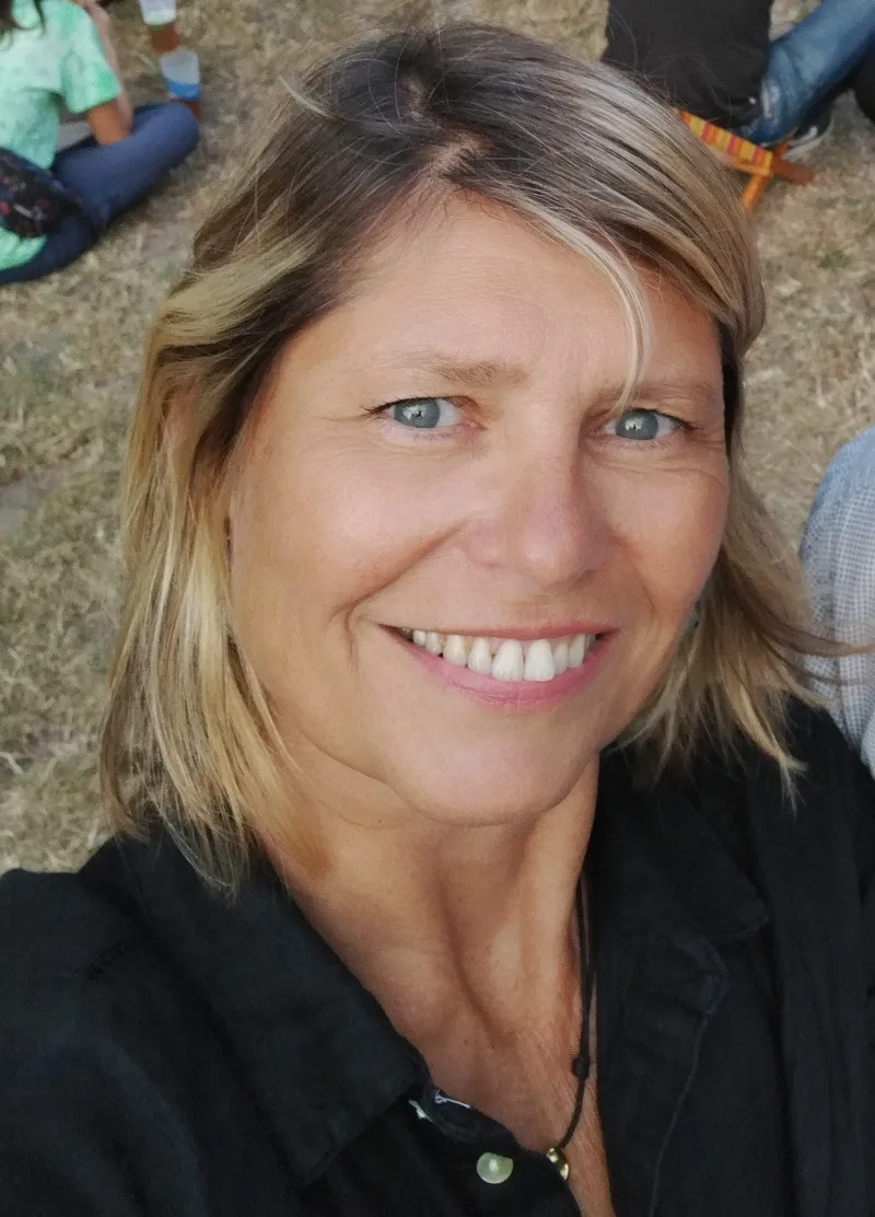 Femme blonde souriante en chemisier noir